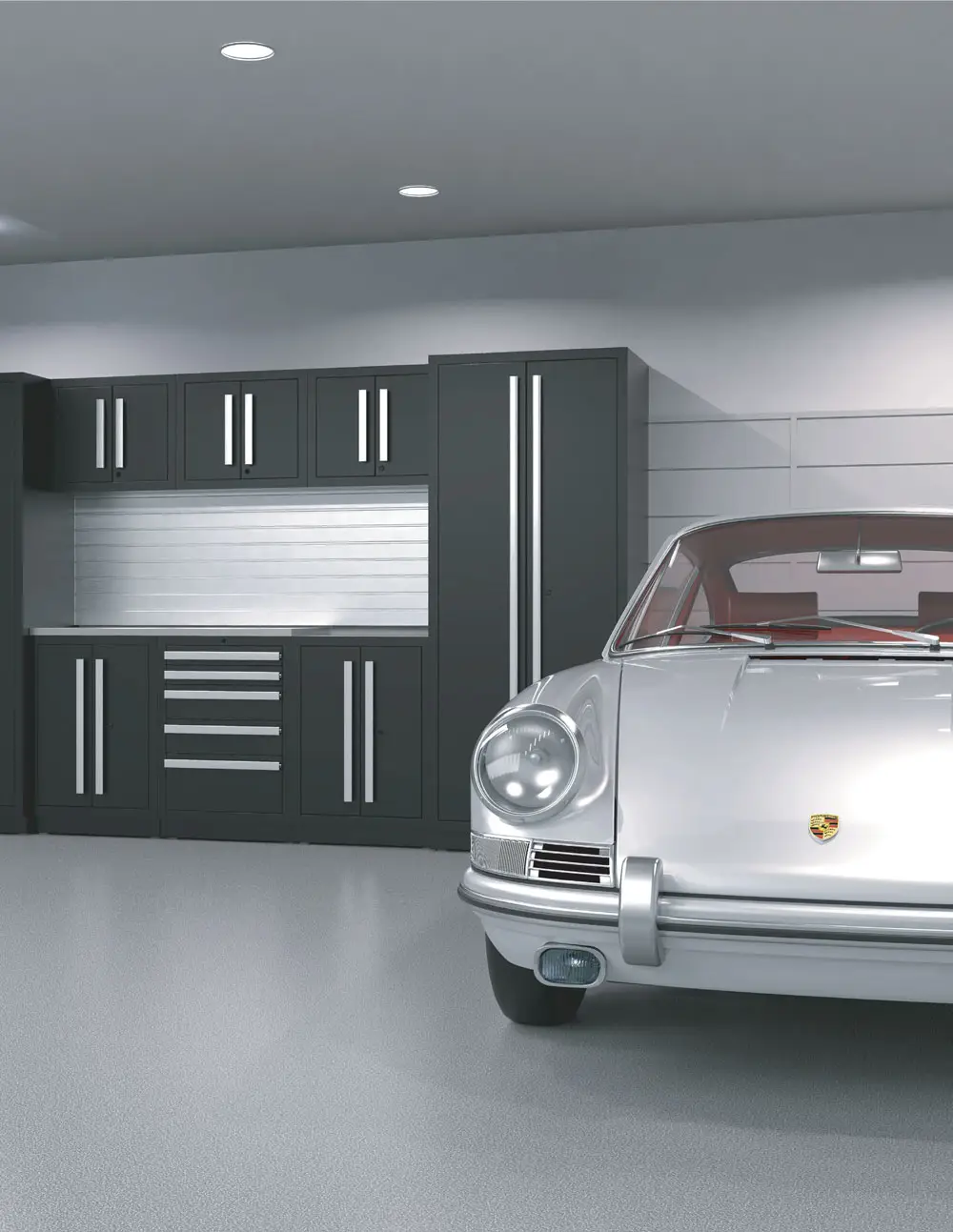 A silver classic Porsche is parked in a modern garage with sleek black garage cabinets, drawers, and metallic accents lining the back wall. The floor is light gray and the lighting is bright and even.