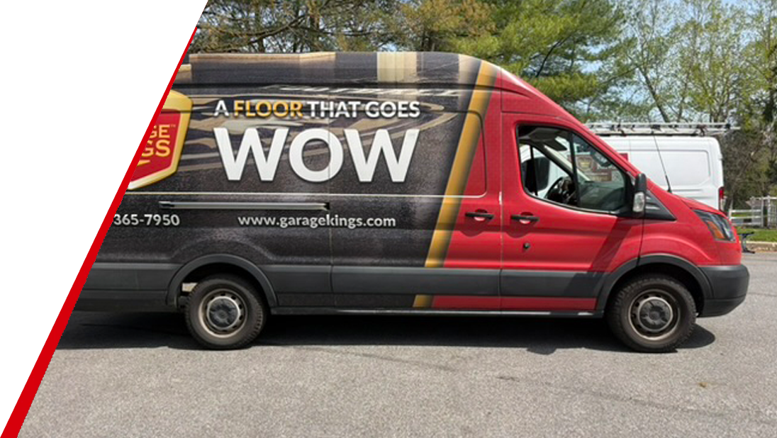 A van with a colorful wrap advertises a flooring company, displaying the slogan A FLOOR THAT GOES WOW on its side, along with the companys website and phone number. Trees and a fence are visible in the background.